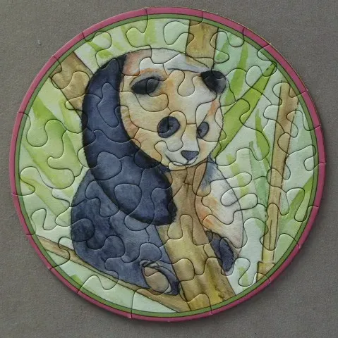 A round watercolor illustration of a panda bear perched in bamboo branches.