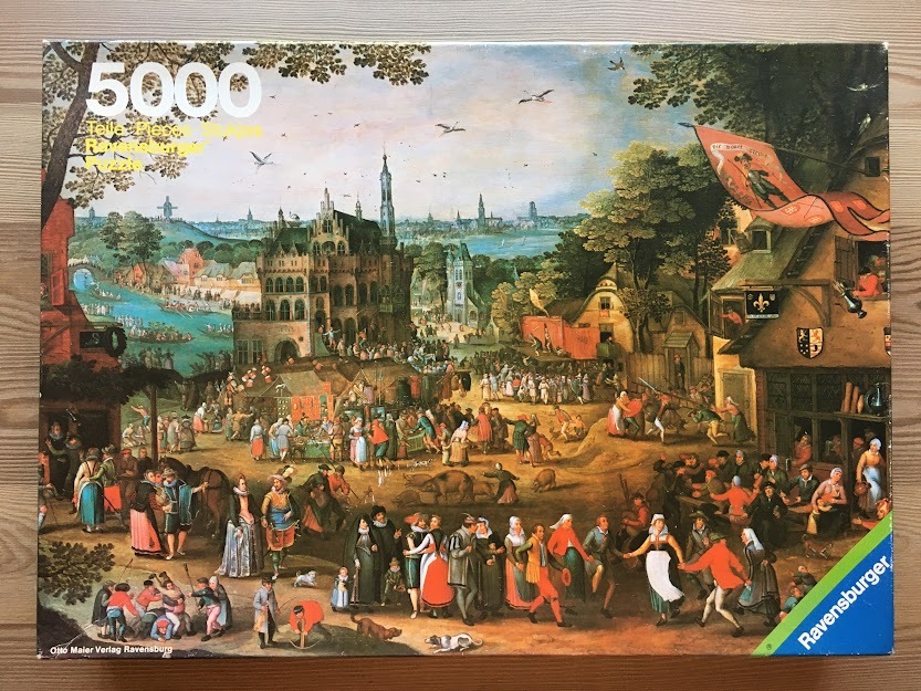 A bustling 16th-century village fair scene in the style of Bruegel with many small figures, buildings, and a river.