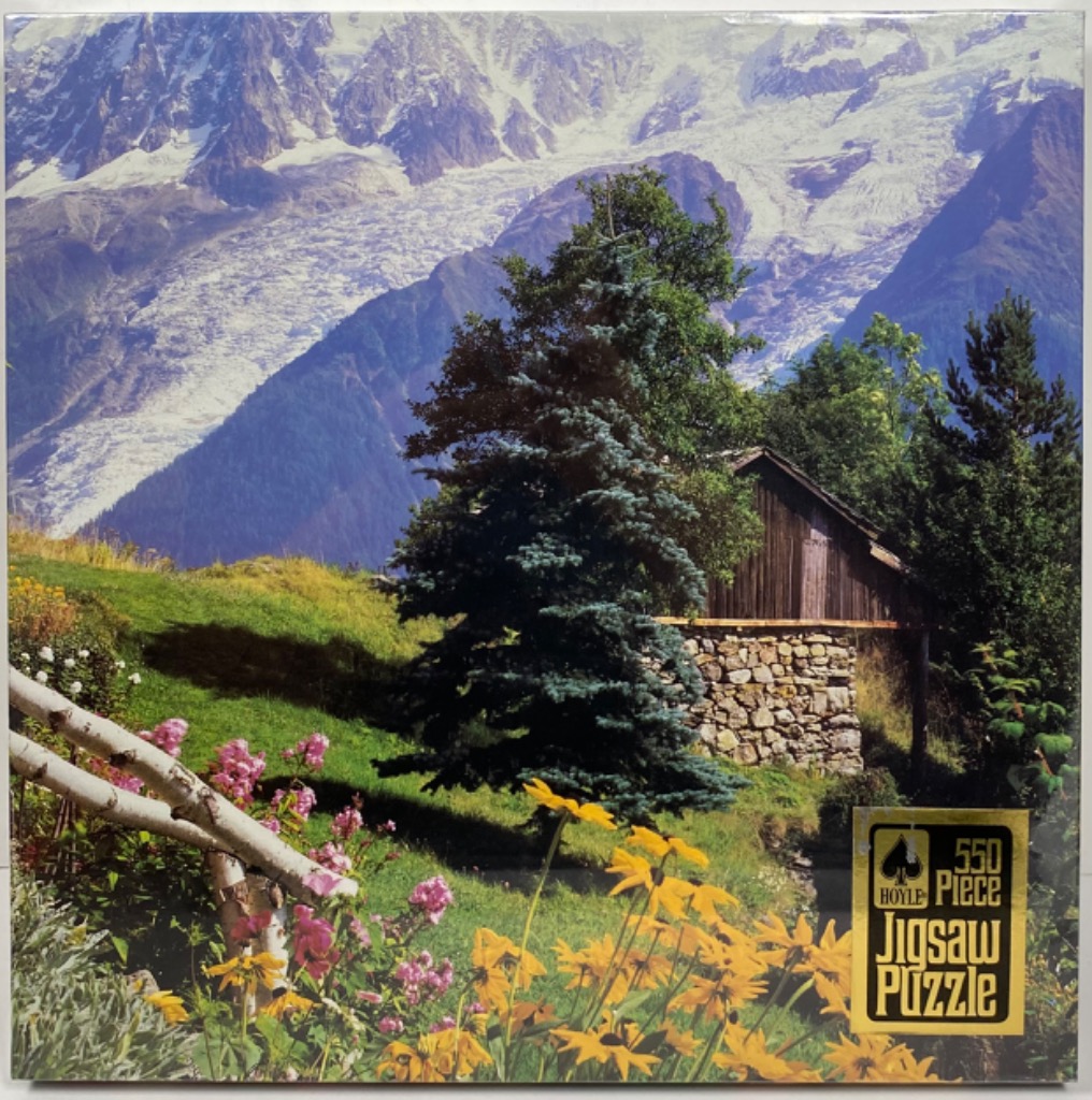 A mountain chalet nestled in a lush alpine meadow with snow-capped peaks in the background.