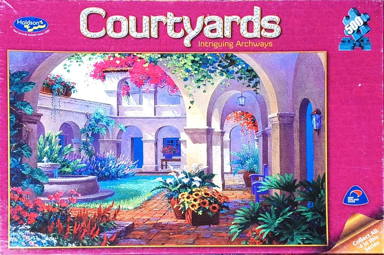 A Mediterranean-style stone courtyard with a central water fountain, blooming flowers, and arched walkways.