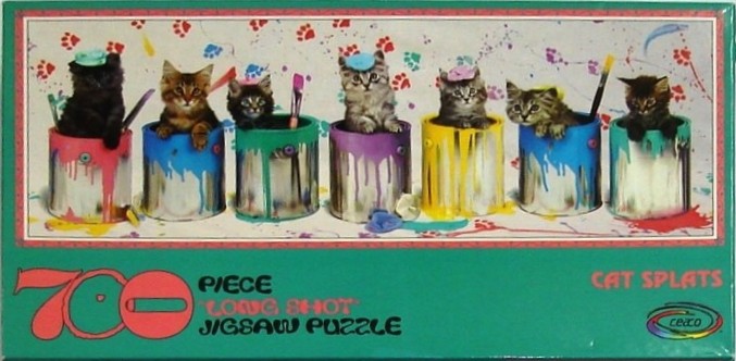 Seven kittens sitting inside colorful metal paint cans against a white background with painted paw prints.