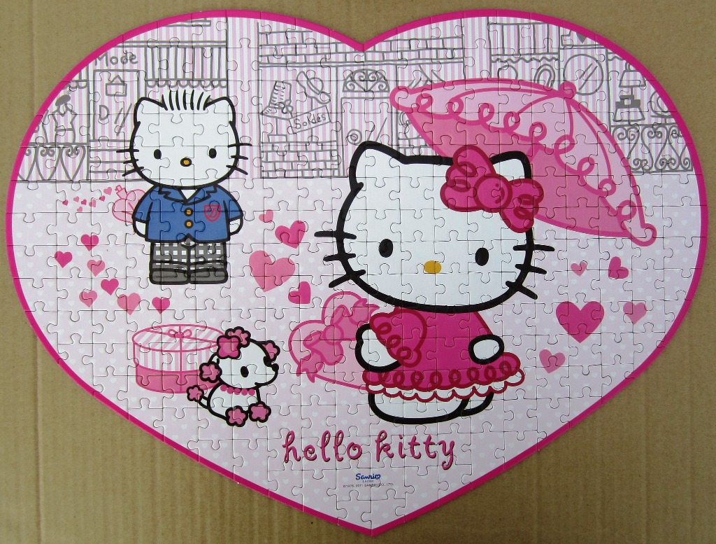 Heart-shaped illustration featuring two Hello Kitty characters, a small dog, and pink hearts against a sketched city backdrop