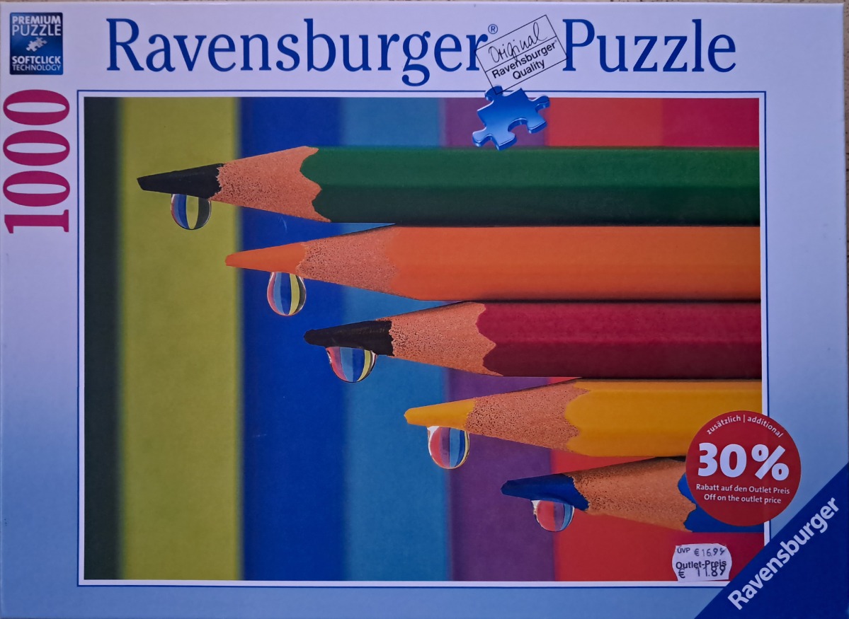 Close-up of five sharpened coloured pencils arranged in a descending staircase pattern with water droplets on each tip.