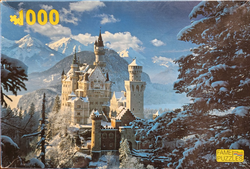 Neuschwanstein Castle in winter, surrounded by snow-covered trees and majestic mountain peaks under a clear blue sky.