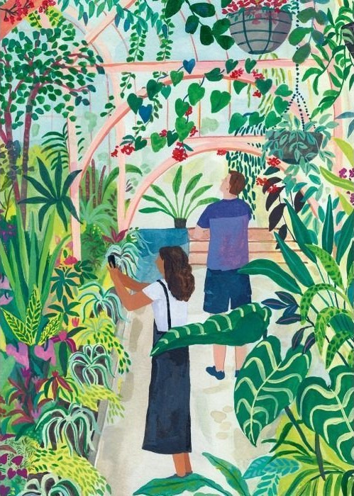 Two people exploring a lush indoor greenhouse filled with various potted plants and hanging greenery.