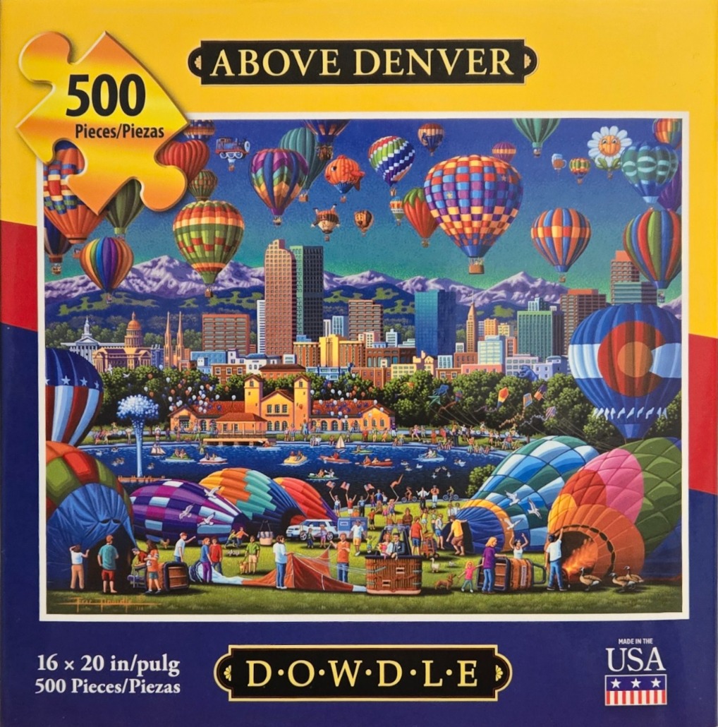 Colorful hot air balloons over the Denver skyline and a park with a lake.