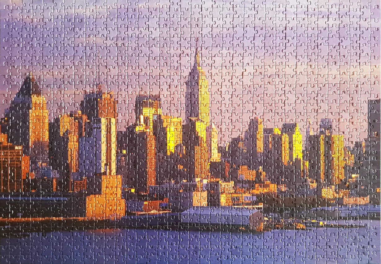 A panoramic photograph of the Manhattan skyline at sunset with golden light reflecting off buildings.