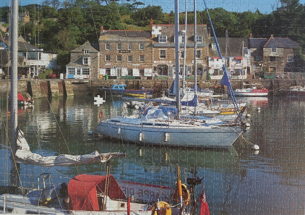 Harbour scene with sailboats docked in front of historic stone buildings