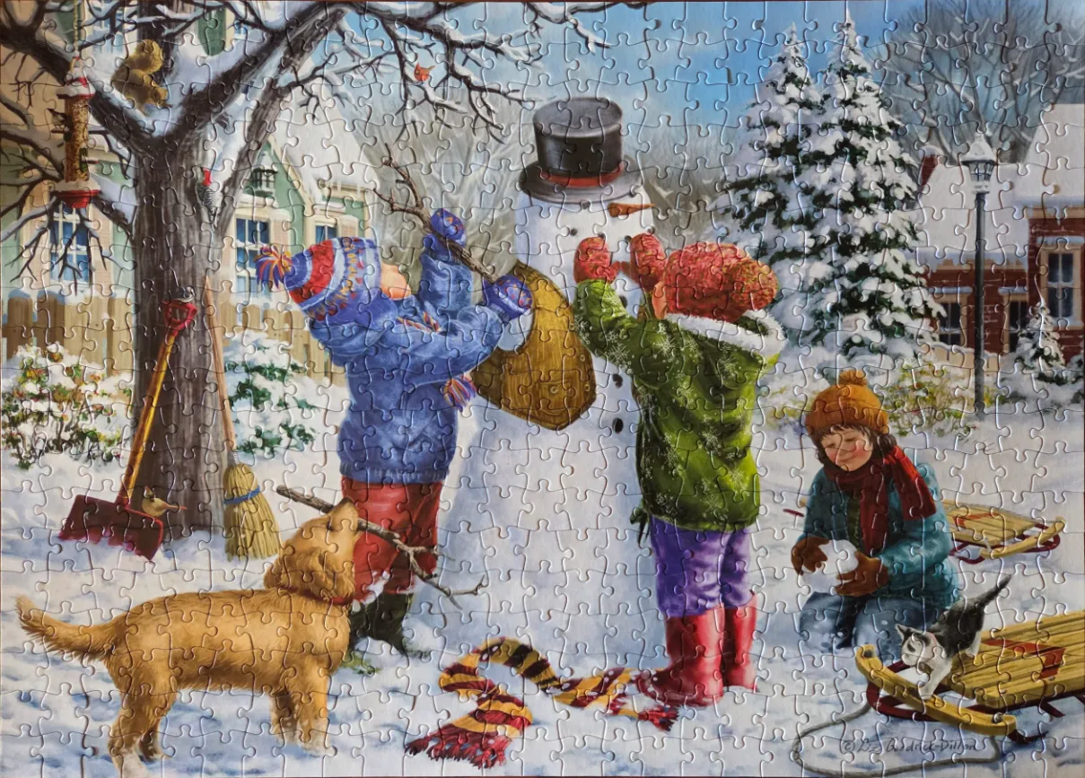 Children building a snowman in a snowy yard with a dog and kitten.