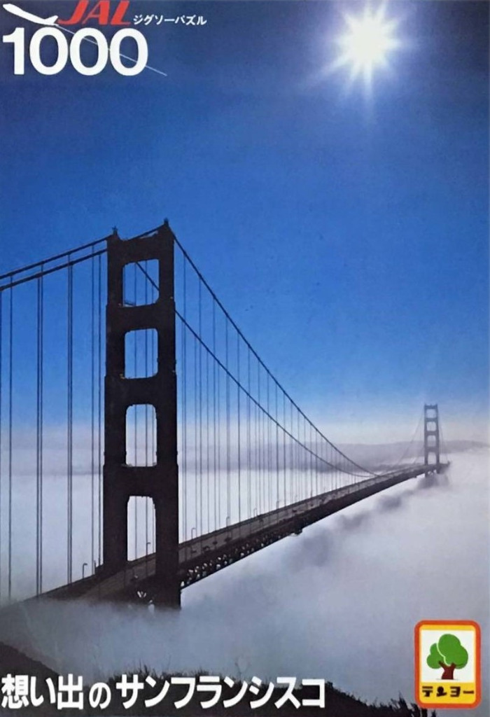 Golden Gate Bridge rising above a thick layer of fog under a bright sun