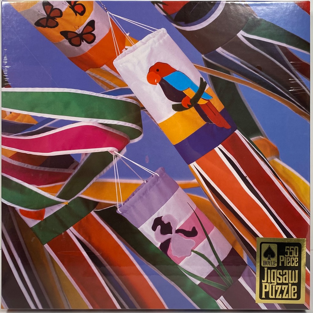 Colorful decorative windsocks featuring butterflies, a parrot, and flowers against a blue background.