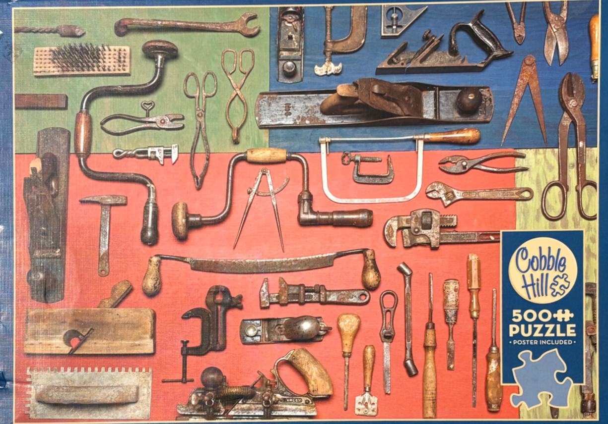 A flat-lay collection of vintage, rusted hand tools arranged against blocks of red, green, and blue background panels.