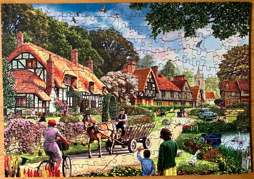 A peaceful English village scene with thatched-roof cottages, a horse-drawn cart, and villagers on a summer day.