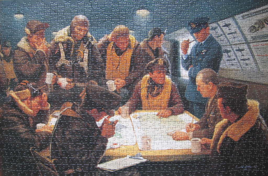 A group of WWII pilots and an officer gathered around a briefing table at night.