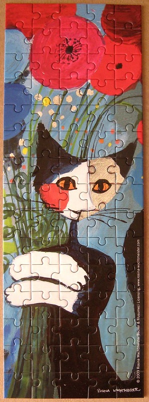 A whimsical illustration of a black and white cat holding a bouquet of red poppies against a blue background.
