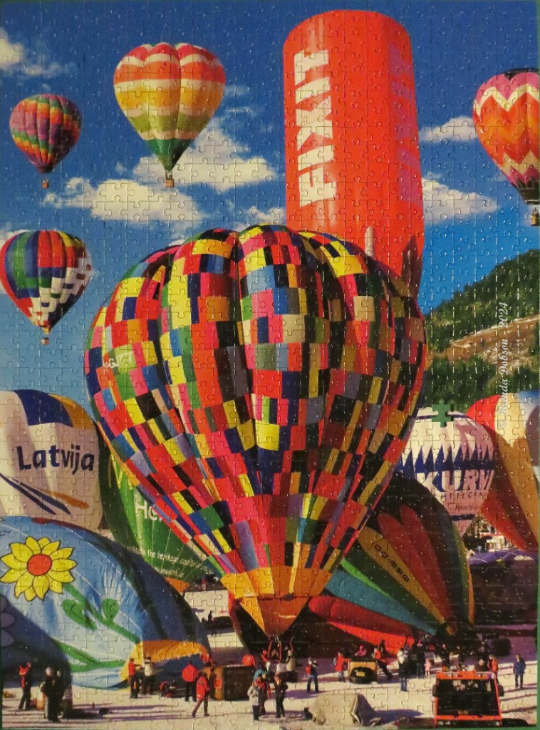 A vibrant scene featuring many colorful hot air balloons on the ground and in a bright blue sky.