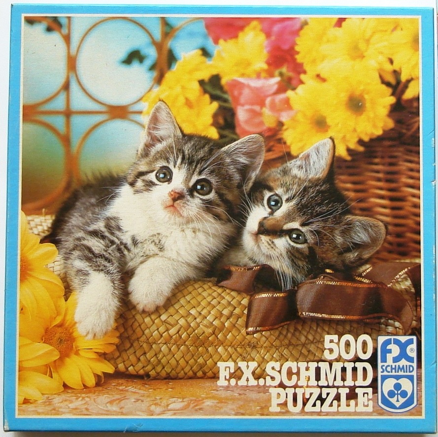 Two small, fluffy tabby kittens resting in a straw basket decorated with yellow flowers and a brown ribbon.