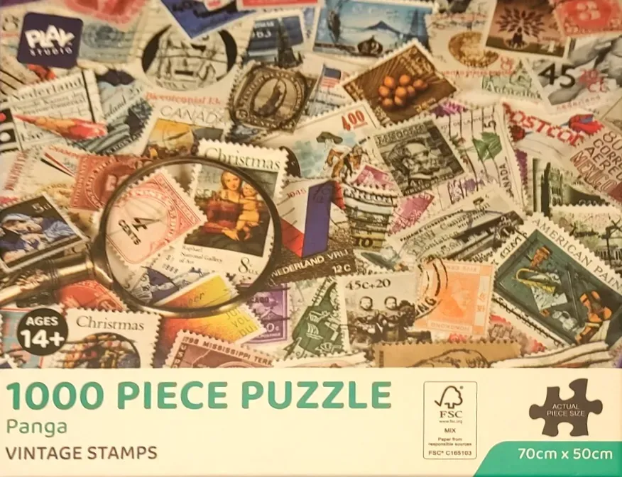 A collection of vintage postage stamps from around the world layered across each other with a magnifying glass.