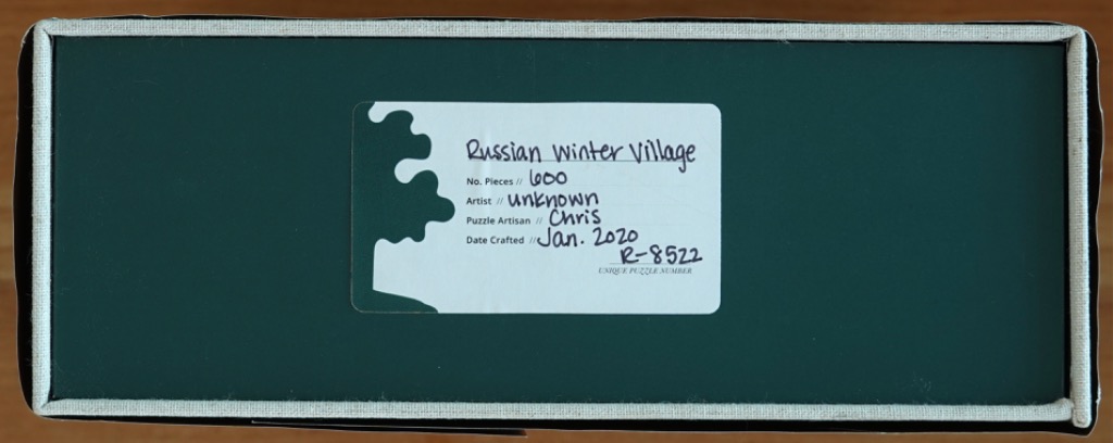 A rectangular dark green label with a white information sticker detailing the specifications of the work.