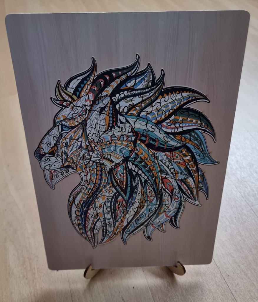 Stylized artistic illustration of a lion head in profile with intricate tribal and geometric patterns.