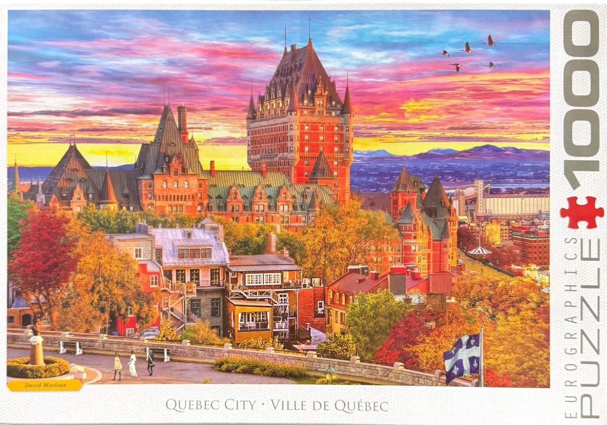 A sunset view of the Fairmont Le Château Frontenac in Quebec City with autumn foliage and a provincial flag.