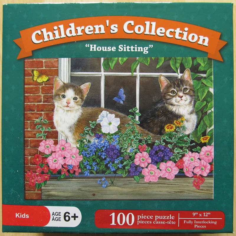 Two kittens sitting in a window box filled with colorful flowers and butterflies.