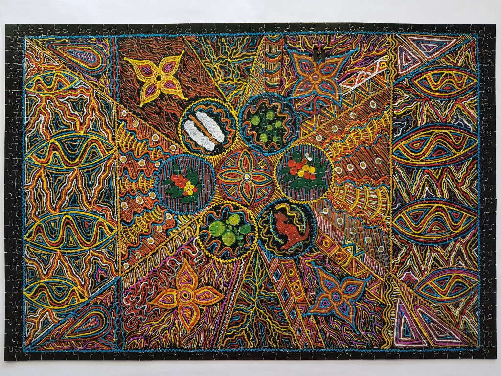 Intricate beadwork-style abstract design with radiating geometric patterns and circular nature-themed motifs.