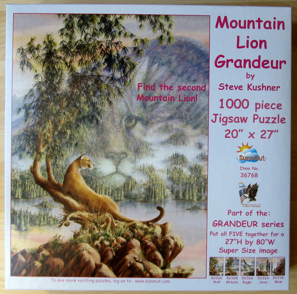 A tan mountain lion sits on a craggy outcrop before a misty lake and a large, hidden spirit-like mountain lion face.