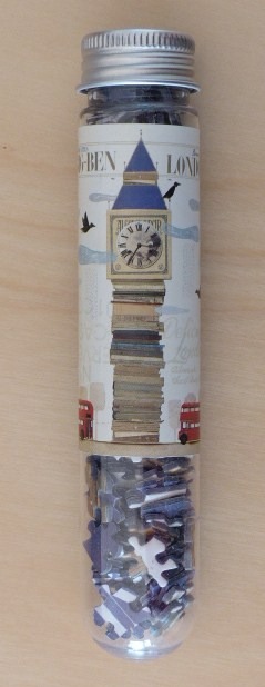Illustration of Big Ben as a stack of books with red London buses at the base on a cylindrical container.