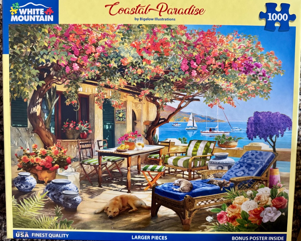 A sunny patio overlooking a blue Mediterranean bay shaded by vibrant pink bougainvillea trees.