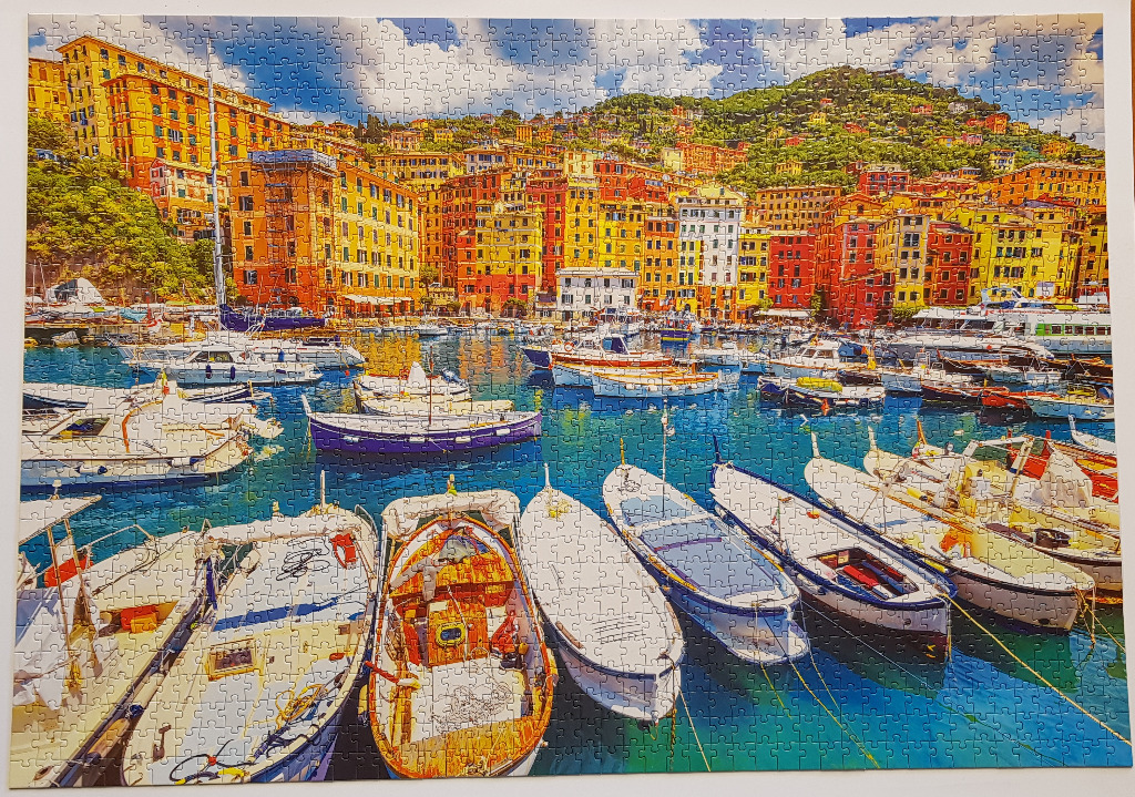 Colorful buildings and fishing boats in a sunny Mediterranean harbor