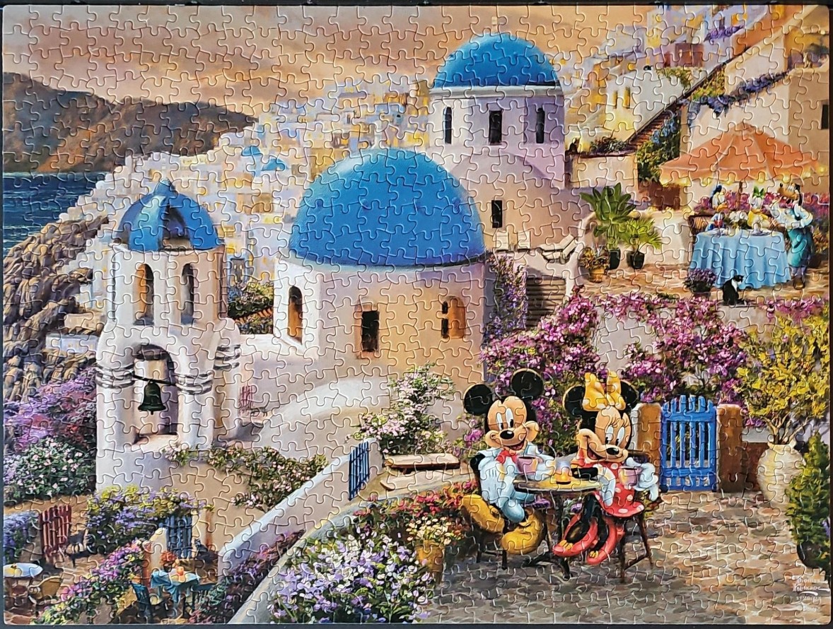 Mickey and Minnie Mouse having coffee on a terrace in Santorini with blue-domed churches in the background.