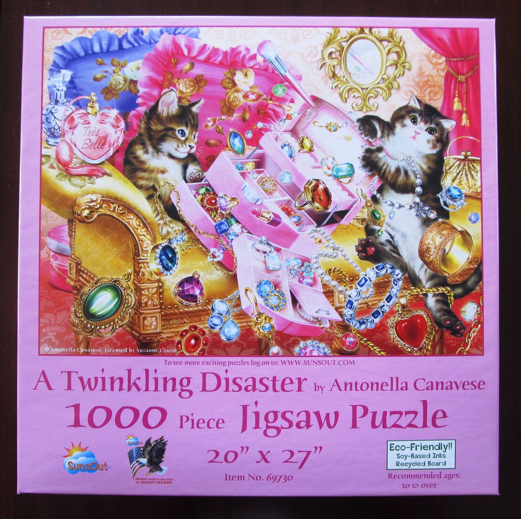 Two kittens playing with jewelry and a vanity case in a plush room.