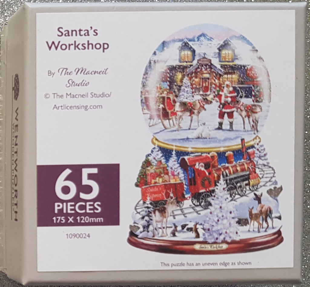 A whimsical snow globe display featuring Santa, his sleigh, and a festive train scene in a snowy landscape.