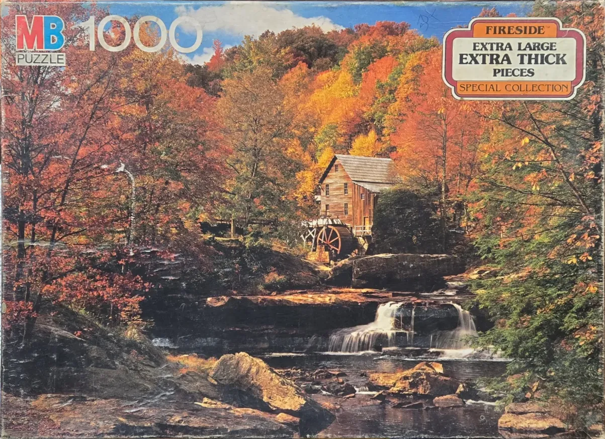 A rustic water mill nestled in a vibrant autumn forest with a waterfall in the foreground.