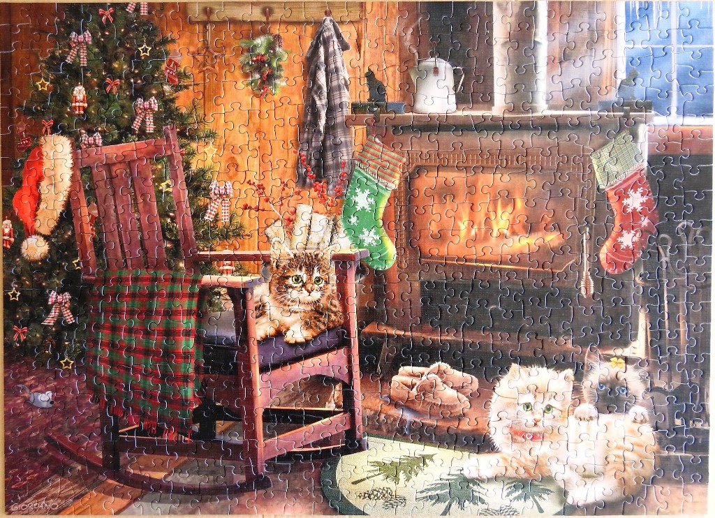 Cozy Christmas scene featuring three kittens in a rustic room with a rocking chair and a fireplace.