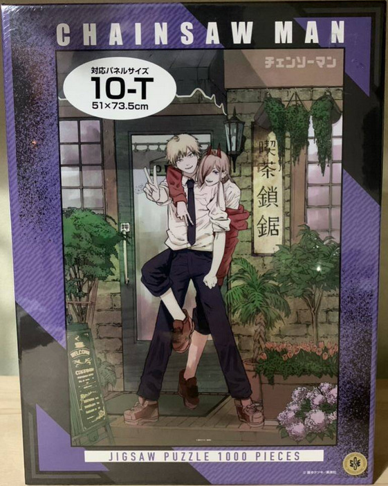 Anime illustration of two characters, Denji and Power, posing together in front of a storefront.