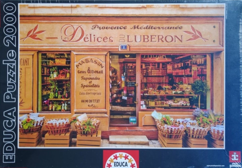 A storefront for a Provençal specialty food shop with baskets of goods on the sidewalk.