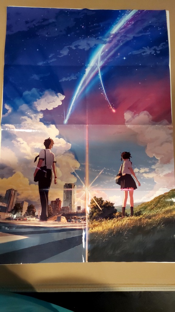 A young man and a young woman standing in different landscapes under a sky with a glowing shooting star.