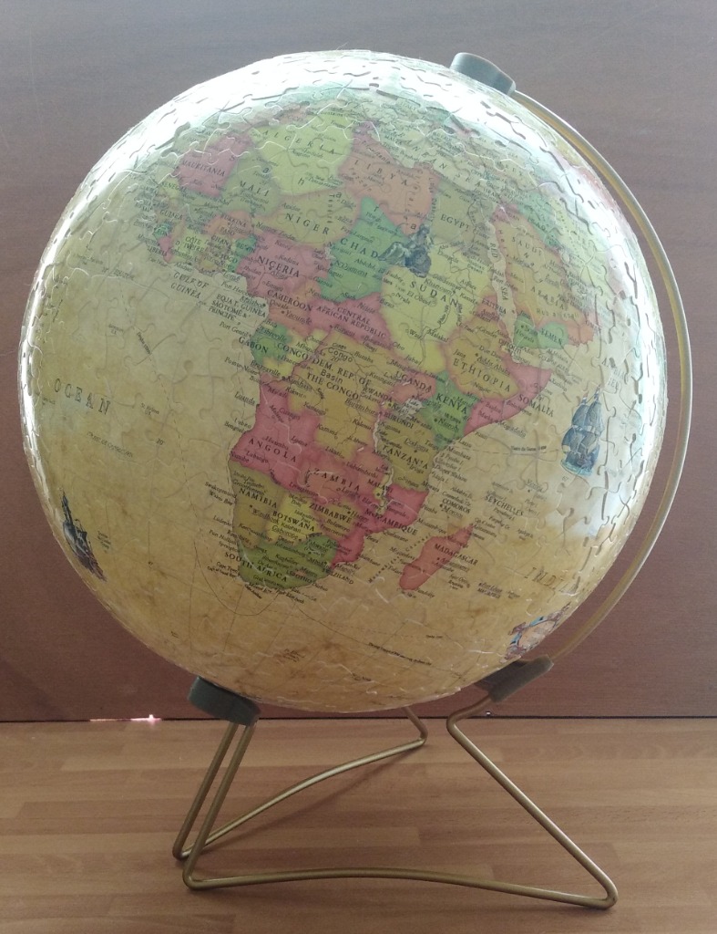 A spherical globe of Earth showing Africa on a simple wire stand.