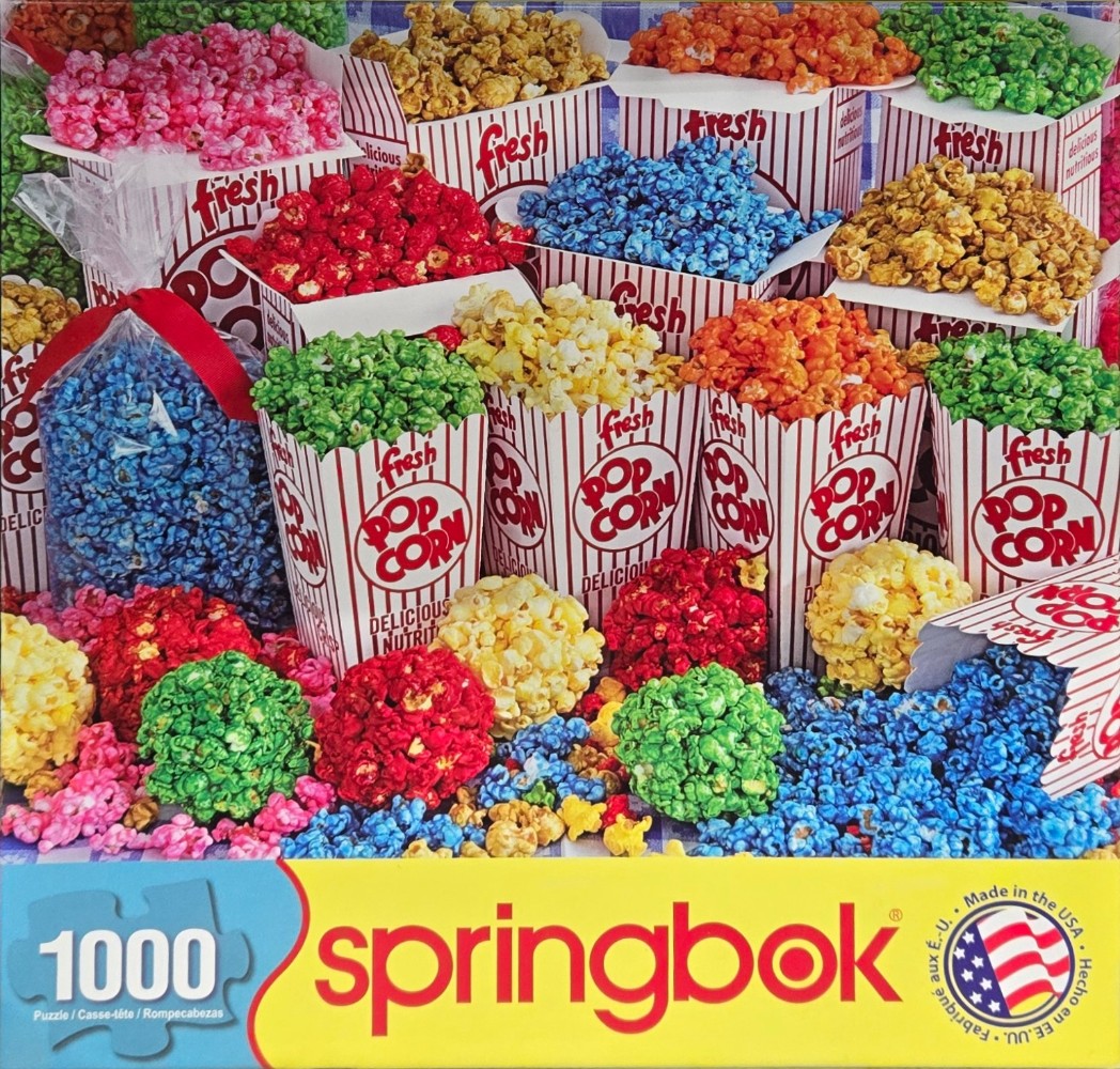 An assortment of vibrantly colored gourmet popcorn in striped red and white containers.