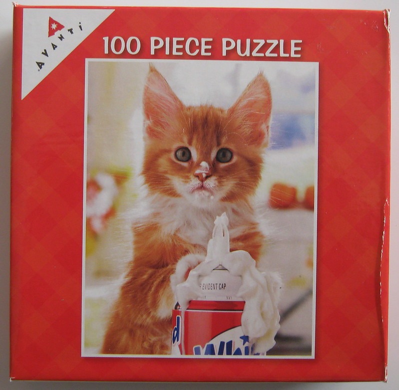 A fluffy orange kitten with whipped cream on its nose and paws