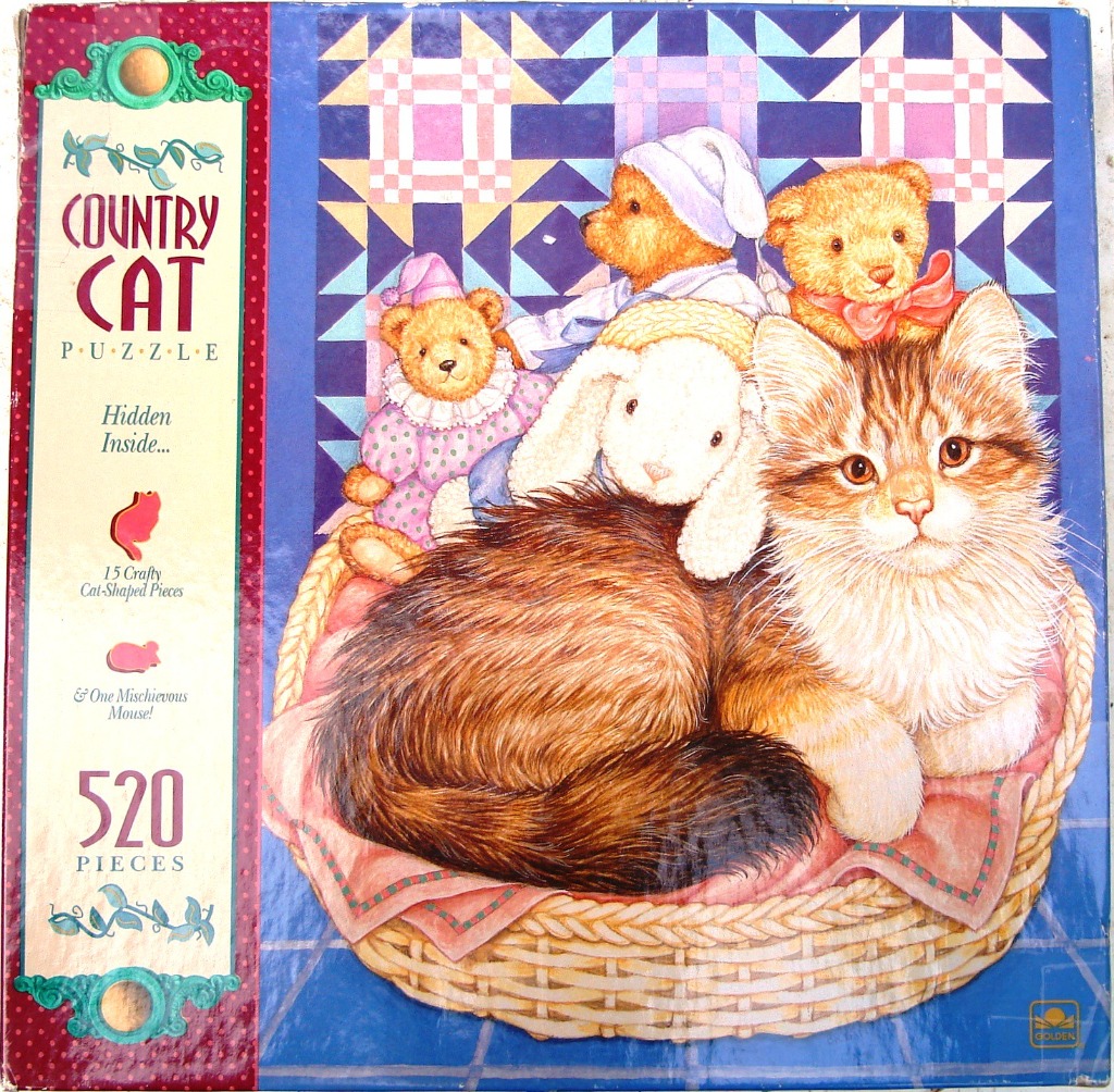 A fluffy ginger tabby cat sits in a wicker basket with three teddy bears and a plush bunny in front of a blue quilt.