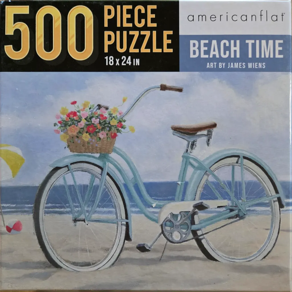 A vintage light blue bicycle with a basket of colorful flowers parked on a sandy beach.