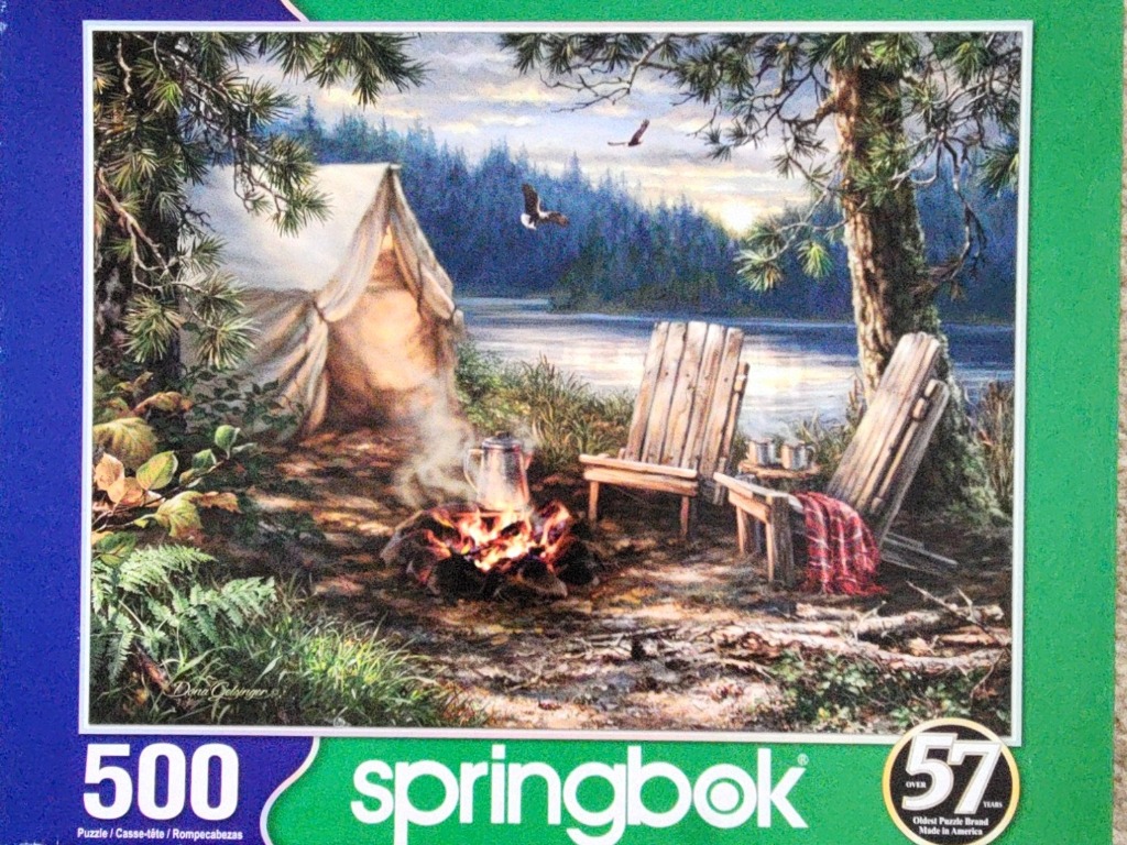 An oil painting of a rustic lakeside campsite at twilight with a campfire, tent, and two wooden chairs.