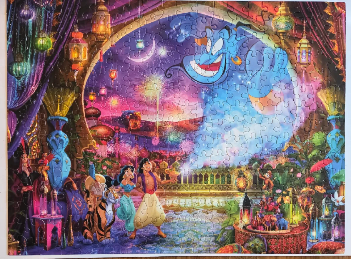 Aladdin, Jasmine, and the Genie against a vibrant purple and orange Middle Eastern palace backdrop with fireworks.