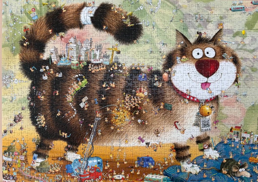 A cartoon illustration of a giant, fluffy cat covered in tiny people and vehicles, viewed against a landscape background.