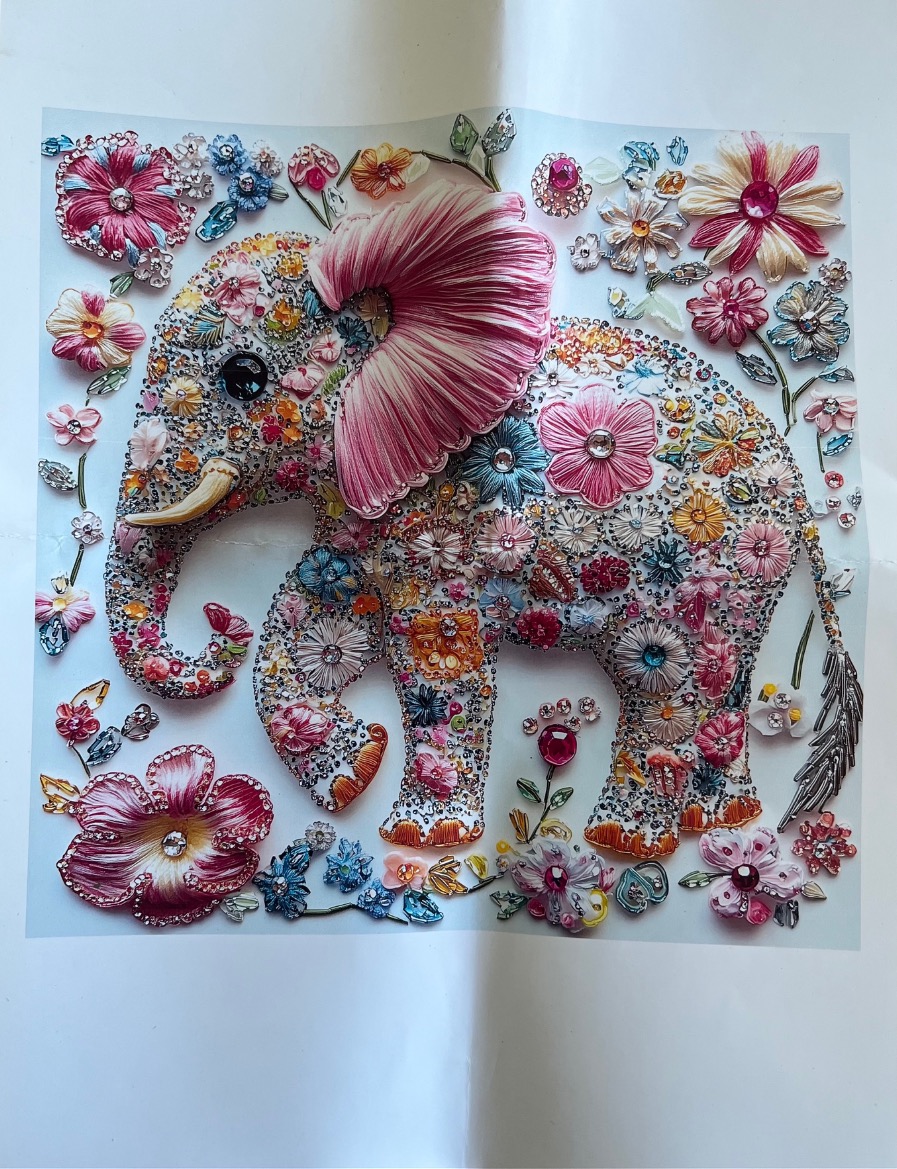 An elephant silhouette filled with colorful floral embroidery and sparkling decorative gems on a white background.