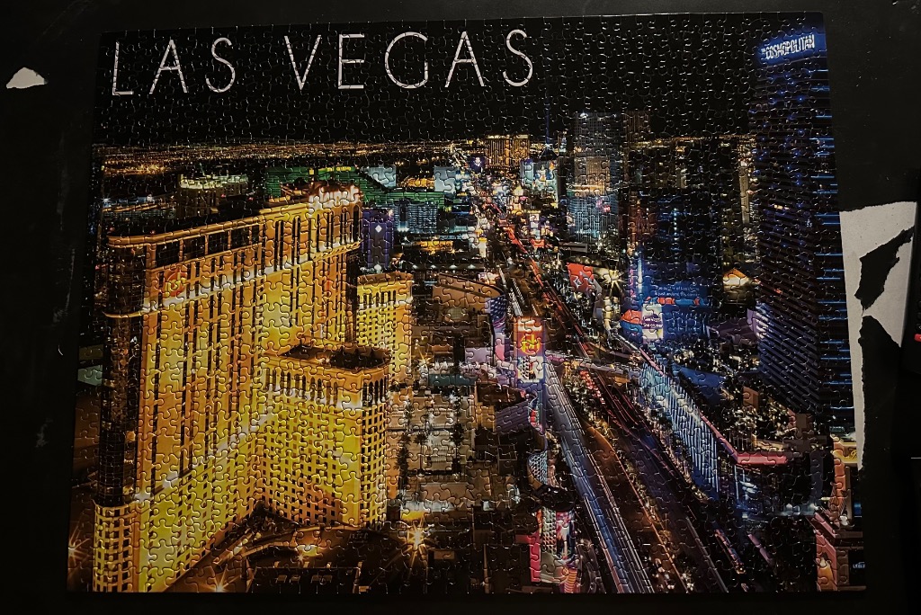 A nighttime aerial view of the Las Vegas Strip featuring bright yellow buildings and city lights.
