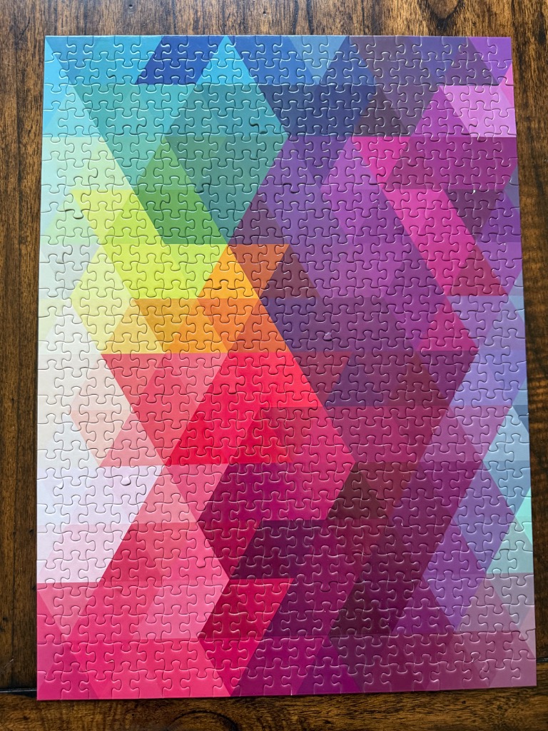 An abstract geometric pattern of multicolored triangles arranged in a color gradient.